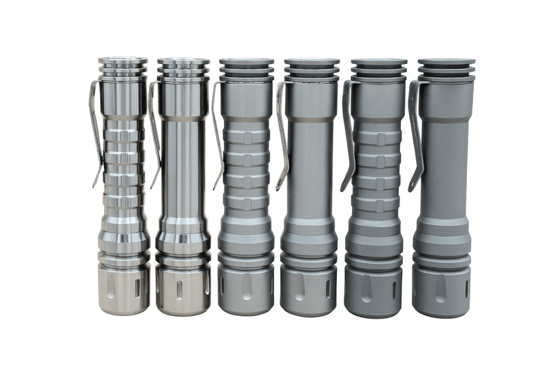 Five metallic flashlights, including the ReyLight LANapple - Ti with Nichia 519a LED, are lined up vertically in varying shades from silver to matte gray against a white background.