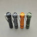 Four different colored flashlights, including the ReyLight Pineapple Mini Aluminum, placed on a gray surface.