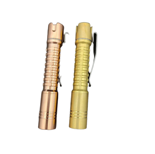 Two different colored ReyLight Pineapple Mini Copper flashlights on a black surface.