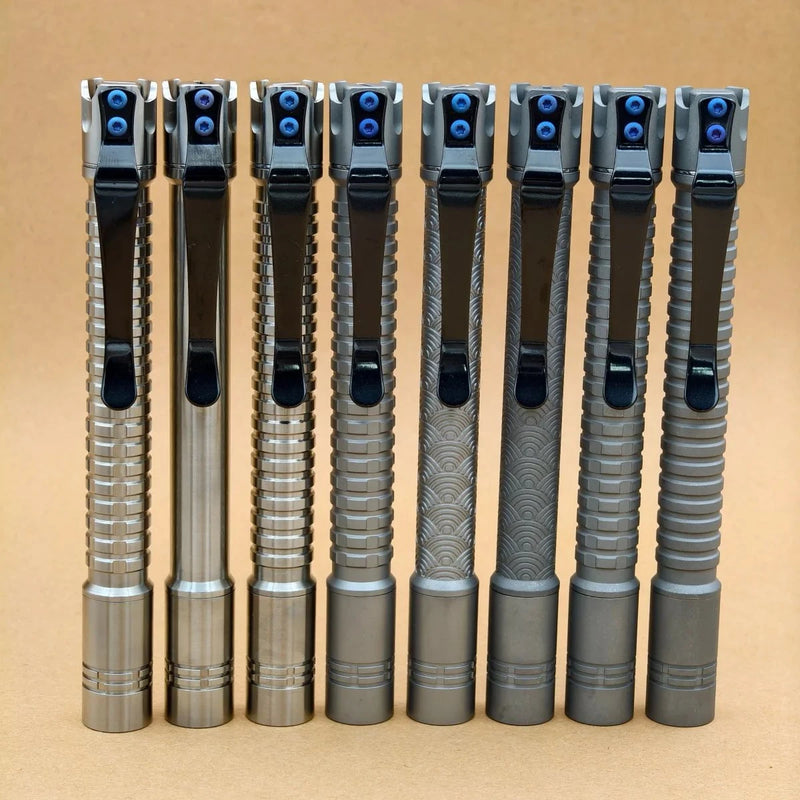 Seven metal pens with textured grips and black clips stand upright in a row against a brown background, echoing the sleek design of the ReyLight Pineapple Mini Penlight - TI.