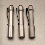 Front view of three stainless steel ReyLight Pineapple Mini flashlights showing lenses and deep-carry clips