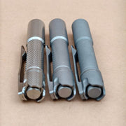 Close view of the diamond cross-hatch machining and recessed tail buttons on three titanium finishes