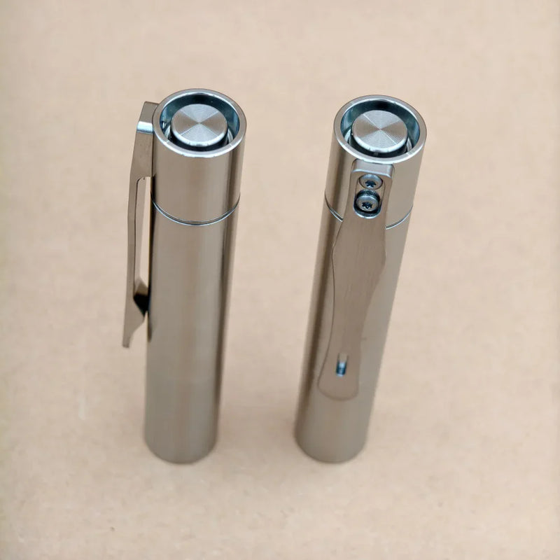 The ReyLight Pineapple Mini Titanium MK3 - Cylinder stands upright on a plain, light brown surface.