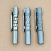Three ReyLight Pineapple Mini Titanium MK3 - Krystal pens with hexagonal grips and pocket clips are arranged side by side on a plain brown surface.