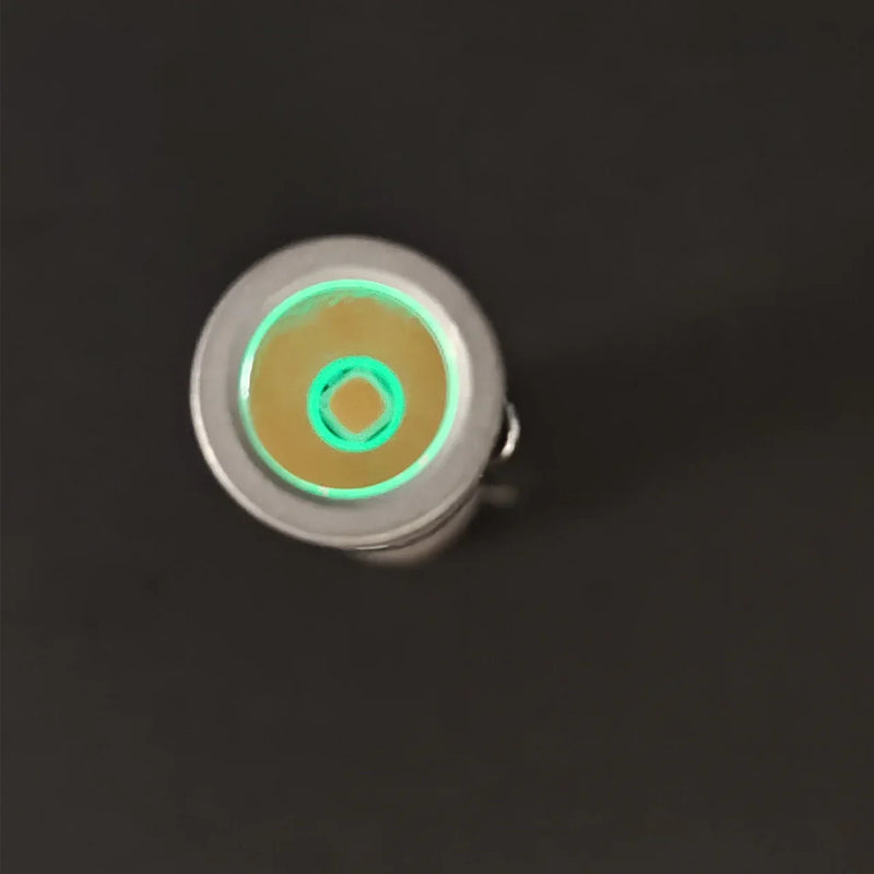 The ReyLight Pineapple Mini Titanium - MK3, a compact circular titanium flashlight with a high-CRI LED, features a yellow center and a glowing green ring, shown against a plain black background.