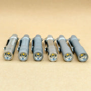 Six ReyLight Pineapple Mini Titanium MK3 flashlights—compact and ideal for everyday carry—are lined up side by side on a plain beige surface, showcasing their lenses and high-CRI LED bulbs.