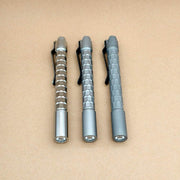 Three ReyLight titanium Krystal penlights showing their faceted bodies and reflector openings