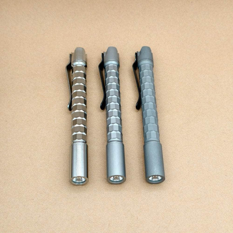 Three ReyLight titanium Krystal penlights showing their faceted bodies and reflector openings