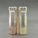 Two metallic flashlights with dual lenses and silver clips stand side by side against a gray background: the copper ReyLight Rook featuring Nichia 519a LED, and its beige brass counterpart, the ReyLight Rook - Brass.
