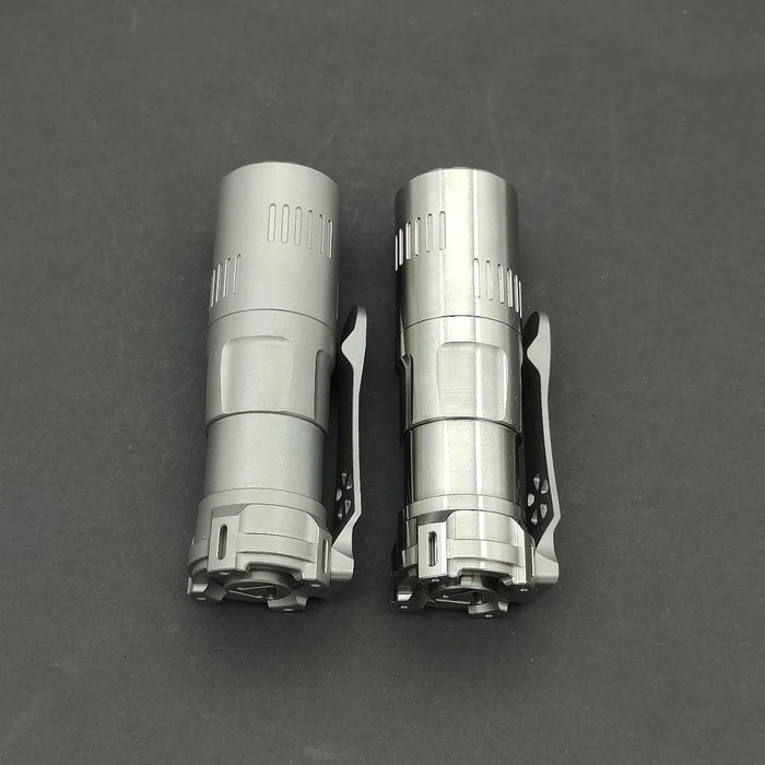 Two Reylight Rook - Ti flashlights on a black surface.