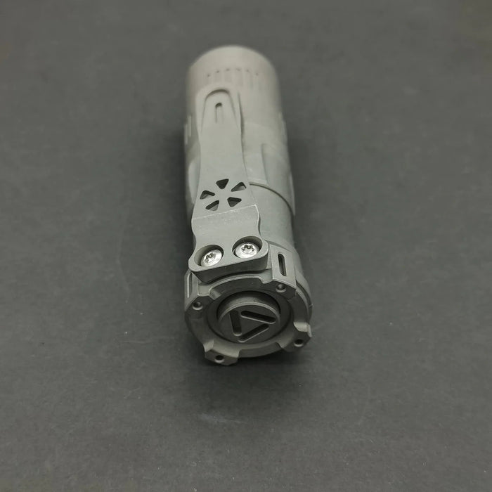 A small Reylight Rook - Ti flashlight on a black surface.