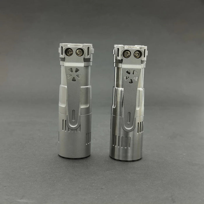 Two Reylight Rook - Ti cigarette lighters on a gray surface.
