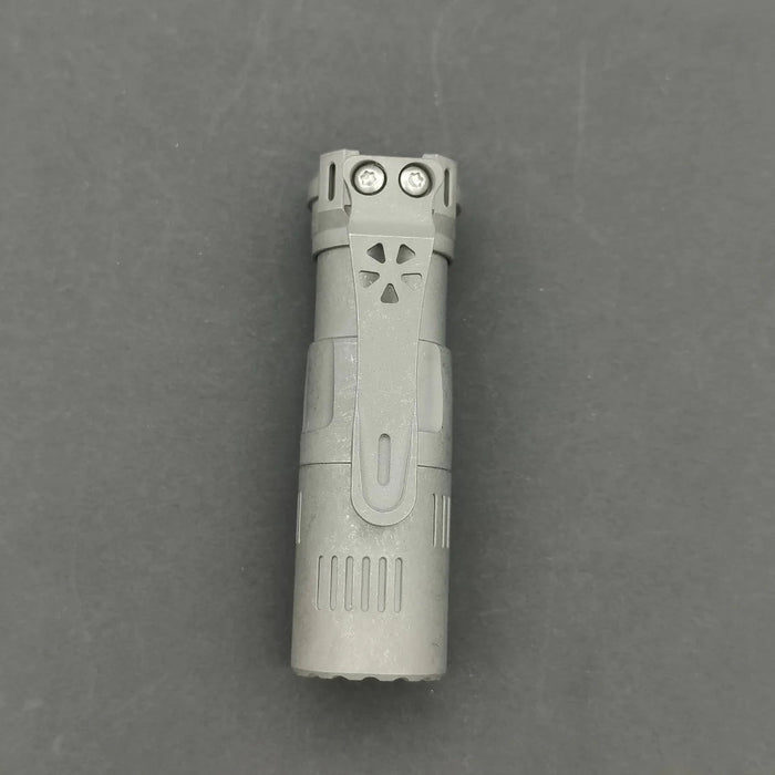 A Reylight Rook - Ti flashlight on a gray surface.