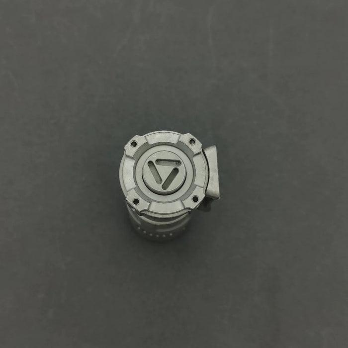 An image of a Reylight Rook - Ti button on a gray surface.