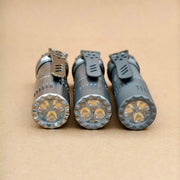 Three ReyLight Rook - Ti gray LED flashlights with metal clips are lined up side by side on a plain brown surface, facing forward to display the bulbs. Each flashlight is powered by an 18350 battery.