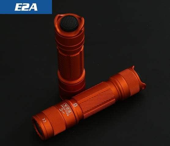 Orange Skilhunt E2A flashlights showing the lens and mechanical tail switch