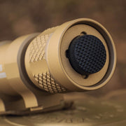 Close-up of the tan-colored Weltool TC70 Tailcap, designed for weapon lights, with a textured black rubber forward-clicking switch.