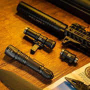 A Weltool LH20 black tactical flashlight attachment (700 lumens, LEP, aluminum reflector) and a multi-tool are arranged on a wooden surface beside part of a rifle and a magazine page.