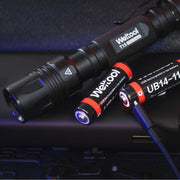 A black Weltool T15 LED tactical flashlight is placed next to two rechargeable lithium-ion batteries, with one battery being charged via a USB cable.