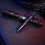 Two black Weltool T15 LED tactical flashlights rest on a textured dark surface, illuminated by blue and red light.