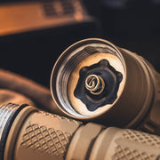 Close-up of the open end of the Weltool W15 “Flying Divinity” LEP Tactical Flashlight, displaying its battery compartment with a visible metal spring inside.