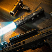 The Weltool W35S, a compact tactical light, emits a bright blue-white beam and sits atop a textured case beside firearm accessories on a wooden surface.
