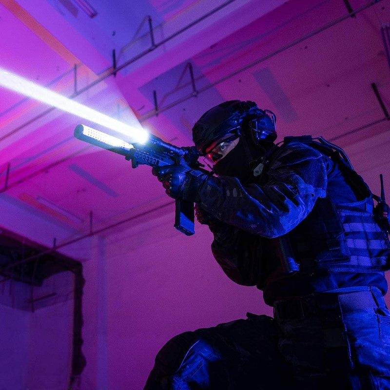 A tactical officer in dark gear aims a rifle equipped with the Weltool W65S, its intense beam cutting through the pink and blue-lit room.