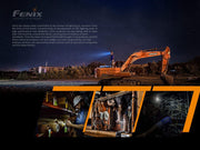 At a nighttime construction site, the versatile Fenix HM61R headlamp brightens the area while someone maneuvers an excavator. On the left, information about Fenix's dedication to providing LED lighting solutions across different industries is displayed, emphasizing advancements such as the dual light sources featured in the Fenix HM61R Headlamp.