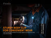 While working on machinery, a person highlights the convenience of the Fenix HM61R by attaching it to their chest with a body clip and utilizing its dual light sources.