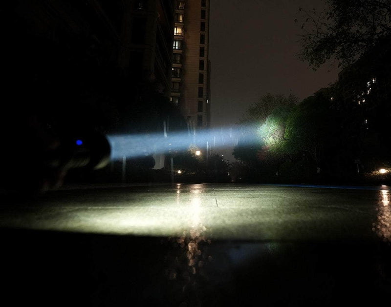 A person is holding a Manker MC13 II in the dark.