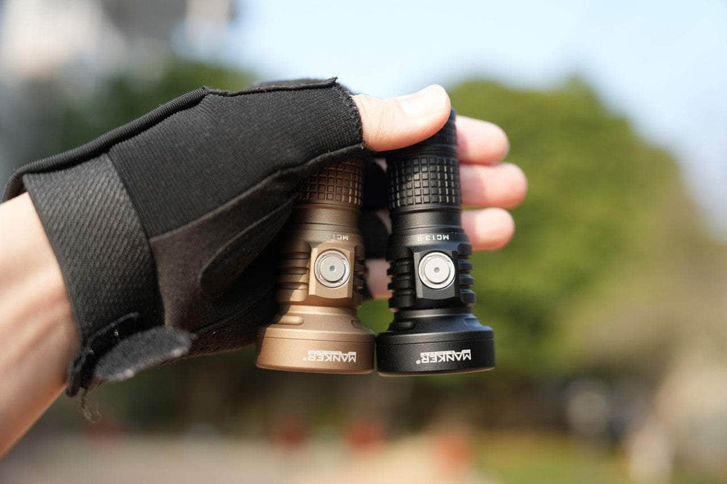 A person holding two Manker MC13 II - SBT90.2 flashlights in their hands.