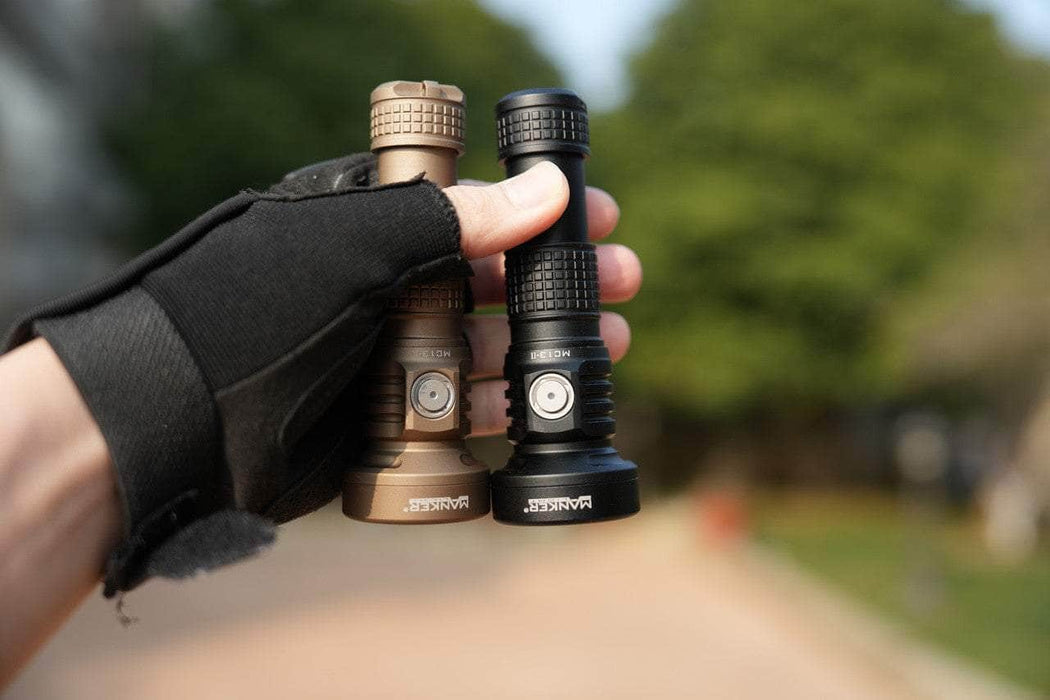 A person holding two Manker MC13 II - SBT90.2 flashlights in their hands.