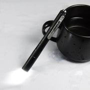 A Manker PL21 is sitting on top of a cup of coffee.