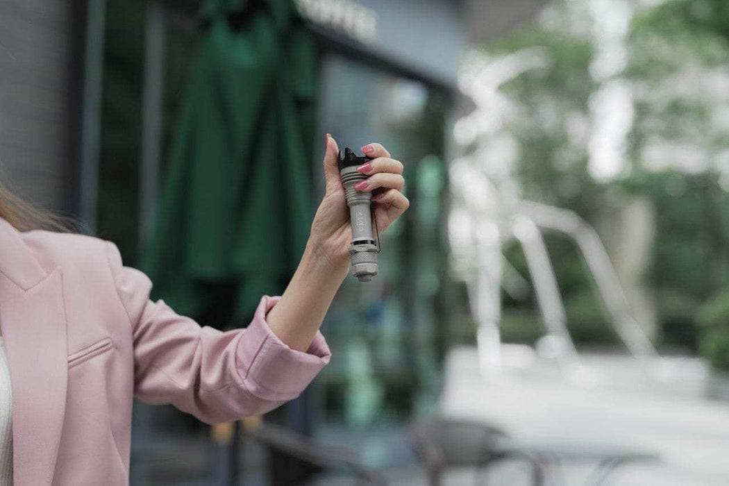 A woman holding a Manker Striker - Aluminum in her hand.