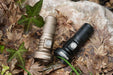 Two Manker MC13 II flashlights laying on the ground.