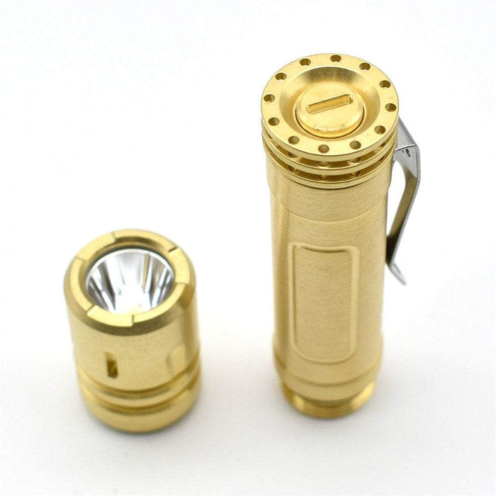 A ReyLight LAN Brass led flashlight next to a white background.