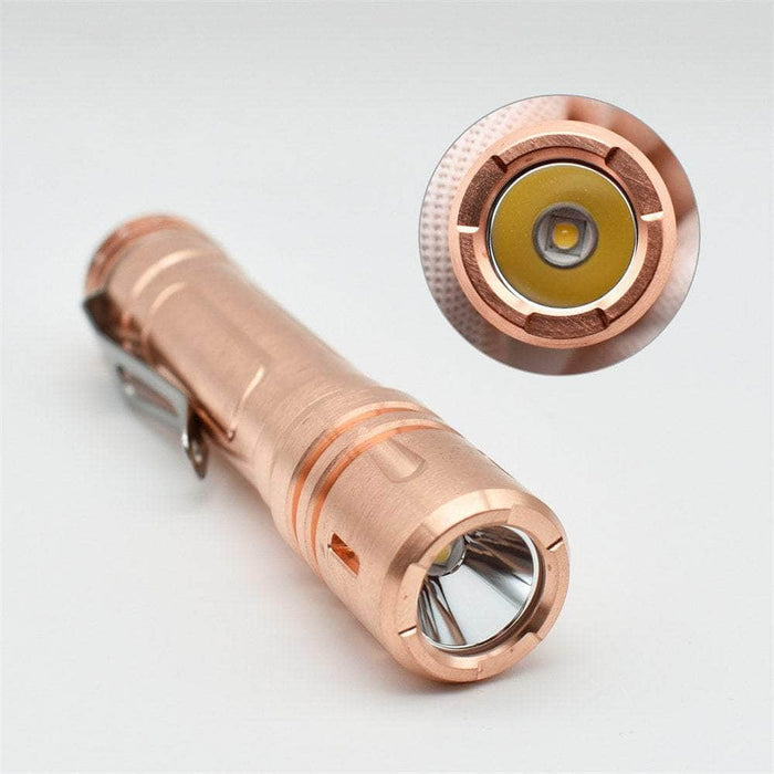 A ReyLight LAN Copper flashlight with a red light.