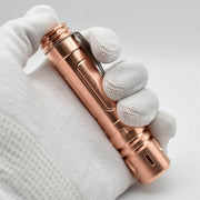 A hand holding a ReyLight LAN Copper flashlight.
