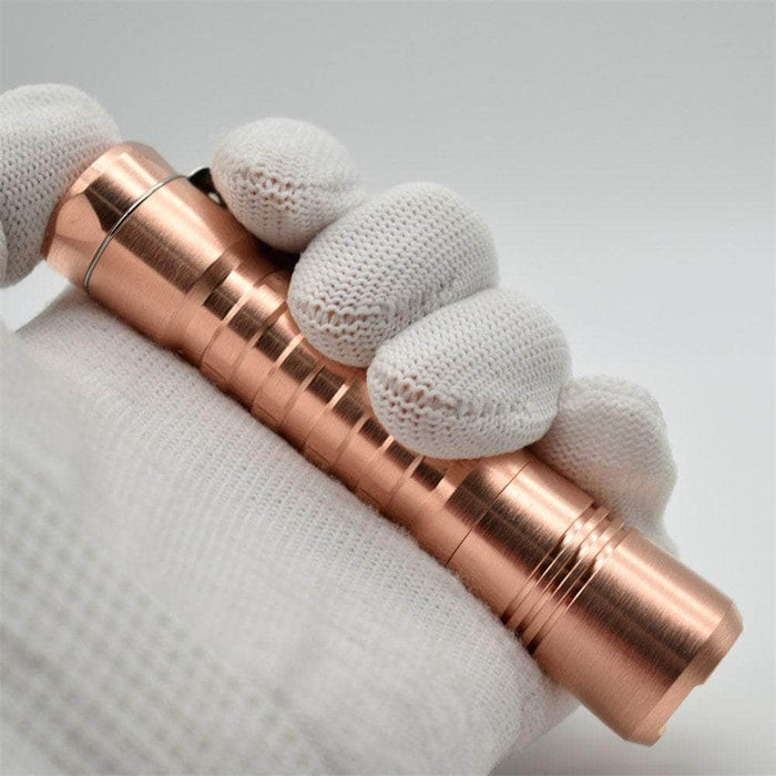 A hand holding a ReyLight Pineapple Copper cigarette lighter.