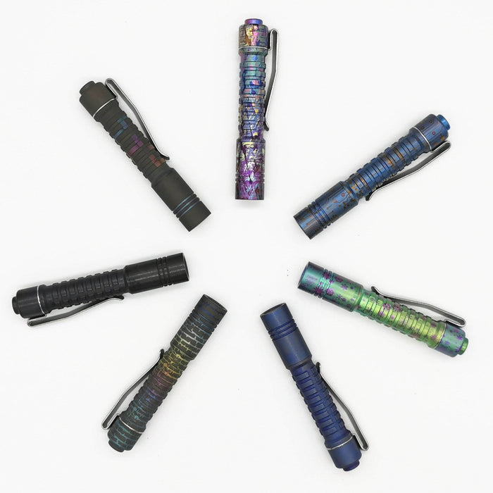 A group of different colored ReyLight Pineapple Mini Titanium Anodized flashlights arranged in a circle.